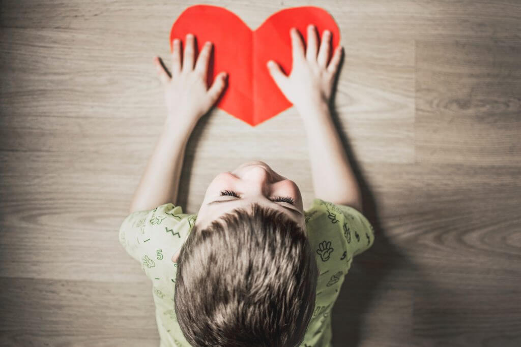 Little boy holding paper heart