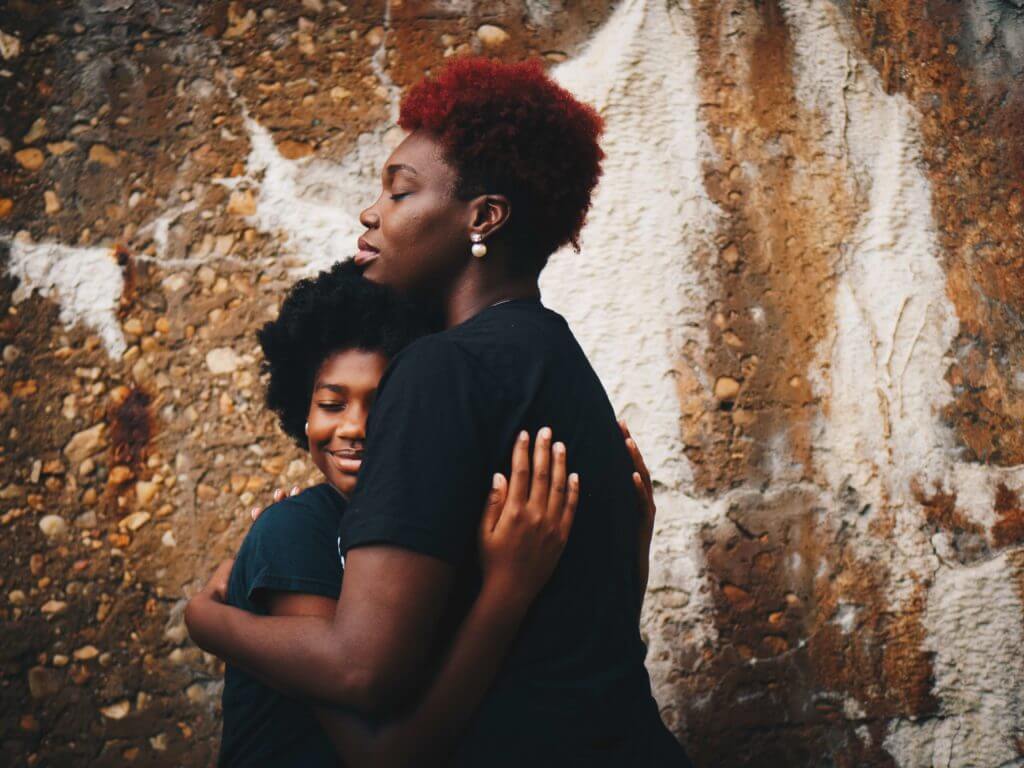 Mother hugging daughter